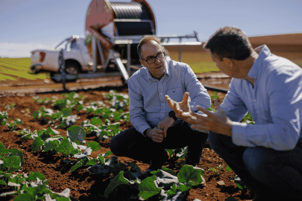 Loaves & Fishes Tasmania CEO Andrew Hillier (left) speaks with a local grower about fresh produce partnerships. Credit: Moon Cheese Studio